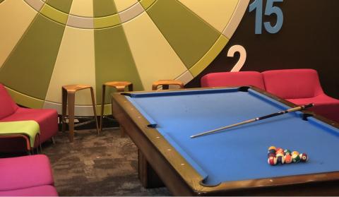 The game room inside University Hall features a pool table, giant dart board, and ample seating.