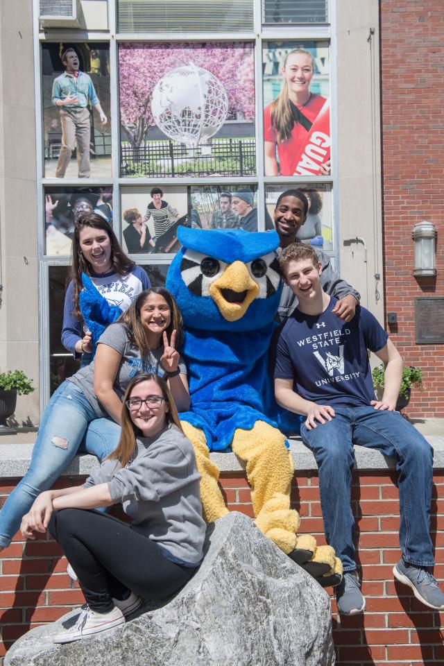 Nestor surrounded by students on front of Parenzo Hall