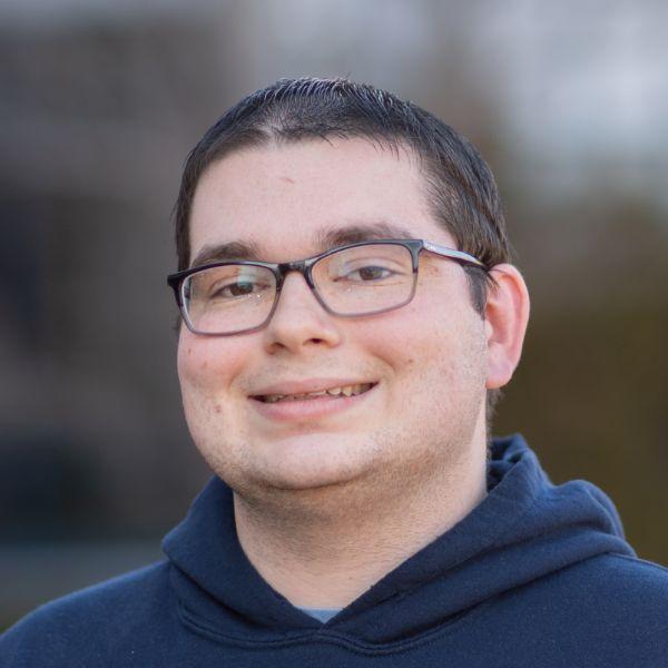 Westfield State University student Daniel Currier smiles for a portrait photograph.