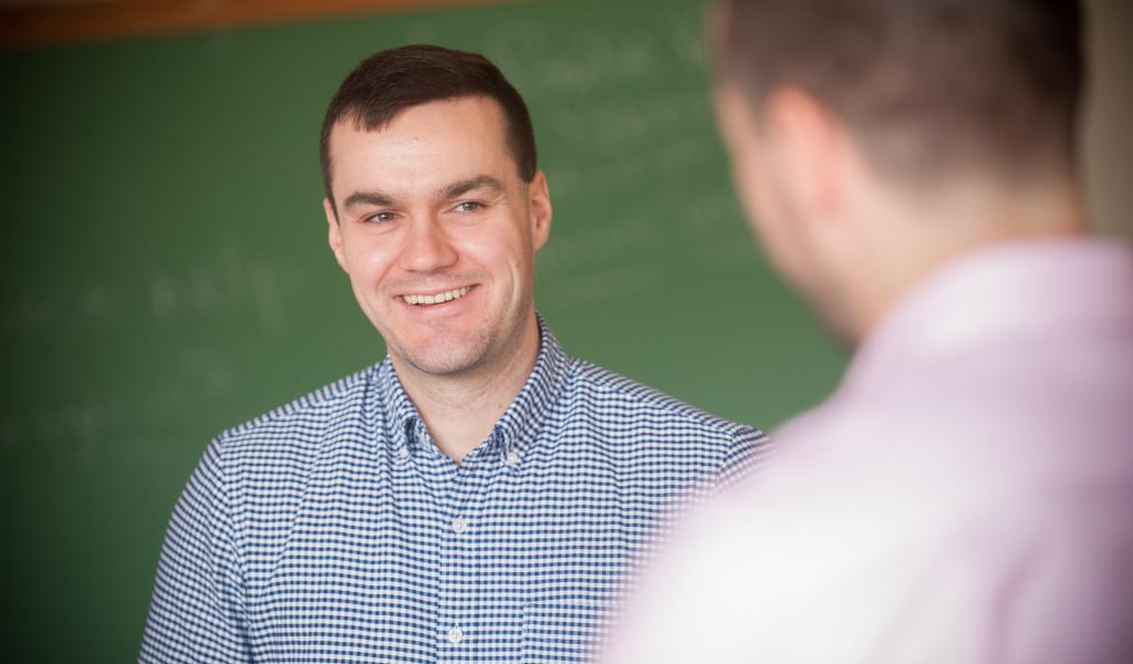 Male student smiling as he talks in the classroom